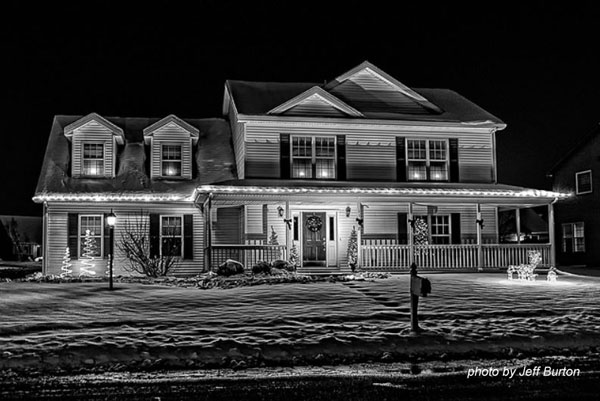 black and white photo of Christmas lights on home